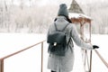 Girl in gray coat on a bridge in winter