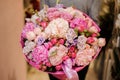 Girl holds a huge bouquet of different pink and purple flowers