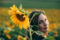 Girl in a green dress and long blond hair in a sunflower field, smiles and enjoys the moment. The concept of summer and sun. Royalty Free Stock Photo