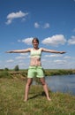 Girl in green exercising on meadow Royalty Free Stock Photo