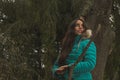 Girl with green jacket in the forest discovering its wonders, its vegetation, its trees and leaves