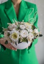 Girl in green jacket holding in her hands a of tender white flowers. Bouquet flowers a girl for mother's day
