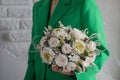 Girl in green jacket holding in her hands a of tender white flowers. Bouquet flowers a girl for mother's day