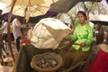 A Girl grilling rice crackers on a traditional charcoal stove a tourist show.