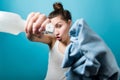 Girl grimacing and fooling around directs a sprayer and a rag into the camera