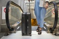 Girl is groing up on escalator with suitcase during holiday trip at airport. Traveling, transfer, waiting at airport