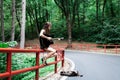 Girl with a guitar and backpack in a road trip with forest view Royalty Free Stock Photo