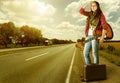 Girl with guitare and suitcase on highway