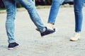 Girl and guy bump feet outdoors. Coronavirus epidemic. Foot shake style of greetings. Coronavirus prevention