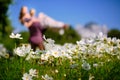 The girl and the guy are a couple, unrecognizable in a blur in the field of cosmos, bright green tones. Bright sunny day