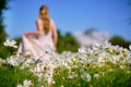 The girl and the guy are a couple, unrecognizable in a blur in the field of cosmos, bright green tones. Bright sunny day