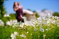 The girl and the guy are a couple, unrecognizable in a blur in the field of cosmos, bright green tones. Bright sunny day