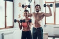 Girl And Guy In Gym Doing Dumbbells Exercises