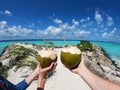 Girl and a guy holding fresh coconuts with a pipe in front of the ocean in the Maldives on a stone pier. Wide format Royalty Free Stock Photo