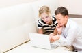 Girl and guy are sitting at a laptop