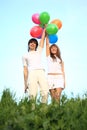 Girl and guy stand with multicoloured balloons