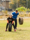 Girl and the guy throw the tire.