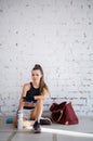 Girl in the gym is wrapping up boxing bandages on her hands before training a blow on a boxing bag Royalty Free Stock Photo