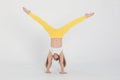 Girl, gymnast, acrobat, dancer, shows trick standing upside down on hands