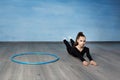 Girl gymnast in a black gymnastic swimsuit warming up before training,