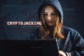 Girl hacker with a face is trying to steal cryptocurrency using a computer. Fraud and scam at Cryptojacking Royalty Free Stock Photo