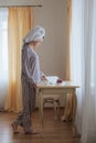 girl with hair wrapped in a towel and in pajamas reading the book on the table with a piece of delicious cake on a Royalty Free Stock Photo