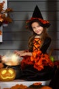 Girl in halloween costume with magic pot Royalty Free Stock Photo