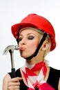 A girl with a hammer and a construction helmet