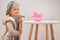 Girl, hammer and piggy bank in portrait for money, finance and investment for future in home. Female person, child and