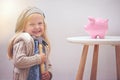 Girl, hammer and piggy bank for savings in portrait, finance and investment for future in home. Female person, child and