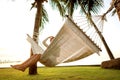 Girl in a hammock bother palm trees enjoying a tropical vacation