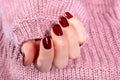 Beautiful Young Woman Hand with Brown Nail Polish on Pink Woolen Sweater Background Royalty Free Stock Photo