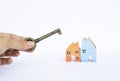 Girl hand holding antique metal key over blurred color wooden miniature house Royalty Free Stock Photo