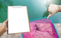 Girl hand holding clipboard with thumbs down hand over dirty swimming pool water Royalty Free Stock Photo