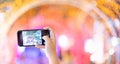 Girl hand holding mobile phone taking the light tunnel decorated for the Christmas and New Year Celebration, and capture picture Royalty Free Stock Photo