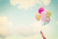 Girl hand holding multicolored balloons