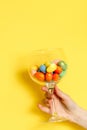 The girl hand holds a glass with Easter eggs.