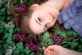 A beautiful girl with hand is lying on the grass in flowers Royalty Free Stock Photo