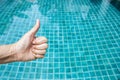 Girl hand over clear blue swimming pool water Royalty Free Stock Photo