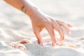 Girl hand picking up seashells on white sand beach at sunset Royalty Free Stock Photo