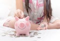 Girl hand put money to piggybank on bedroom Royalty Free Stock Photo