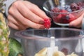 Vibrant Blend: Girl Adding Raspberries to a Healthy Fruit Smoothie