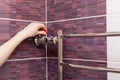 The girl hand regulates the water tap in the heated towel rail. Royalty Free Stock Photo