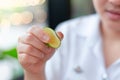 Girl hand squeezing a little lime lemon juice