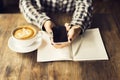 Girl hands with cell phone, cup of coffee and blank diary with p Royalty Free Stock Photo