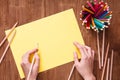 Girl hands drawing, blank yellow paper and colorful pencils on old wooden table Royalty Free Stock Photo