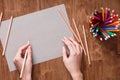 Girl hands drawing, blank yellow paper and colorful pencils on old wooden table Royalty Free Stock Photo