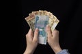 Girl in hands holding money, euro, rubles and dollars, black background, close-up finance Royalty Free Stock Photo