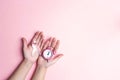 Girl hands holding pink breast cancer awareness ribbon and alarm Royalty Free Stock Photo