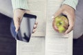 Girl hands keeping smartphone, apple and open books Royalty Free Stock Photo